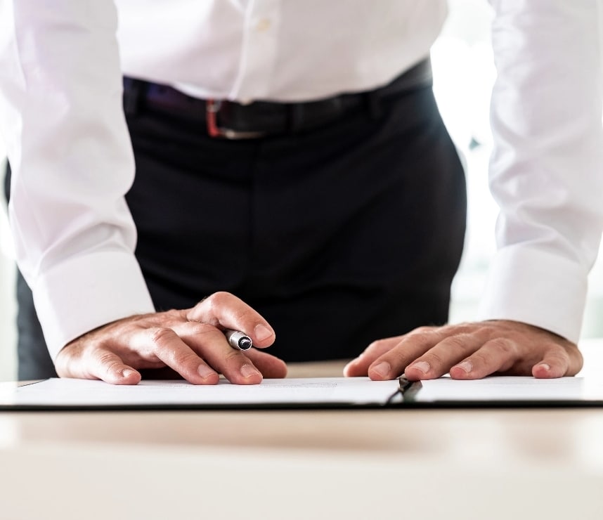 Photo du bas de ventre et bassin d'un homme en chemise avec les mains posées sur la table
