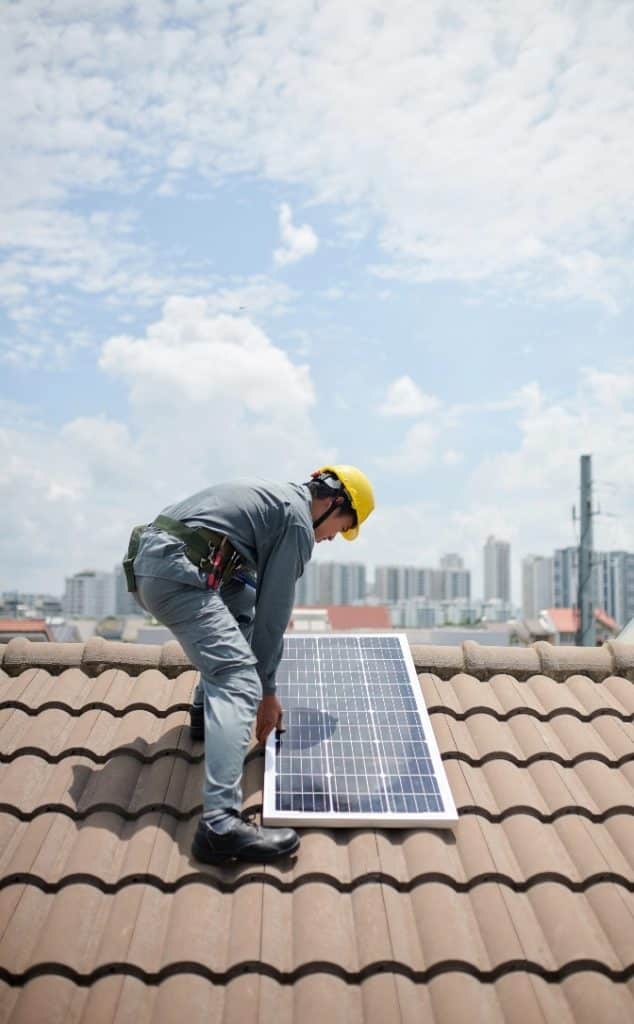Un ouvrier installe un panneau solaire sur un toit